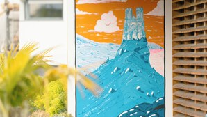 Un mural que muestra una montaña con una cascada en la pared exterior de un edificio.