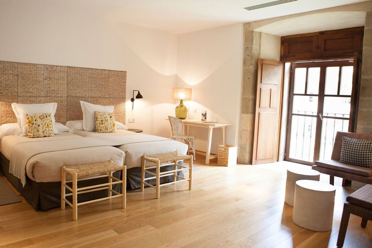 Une chambre à coucher avec un grand lit, des tables de chevet, un bureau et une chaise.