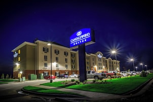 Un hotel con un cartel llamativo, varios espacios de estacionamiento y un exterior bien iluminado.
