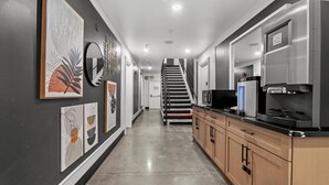 A modern kitchen with a stainless steel refrigerator, a microwave, and a built-in oven. There is a wooden cabinet and a black countertop. - Le Bon Hotel Hollywood (Los Angeles)