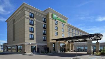 A Holiday Inn hotel with a modern facade, multiple floors, and a covered entrance area.