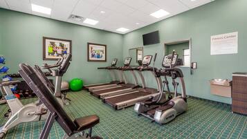 A fitness center with treadmills, stationary bikes, and exercise balls.
