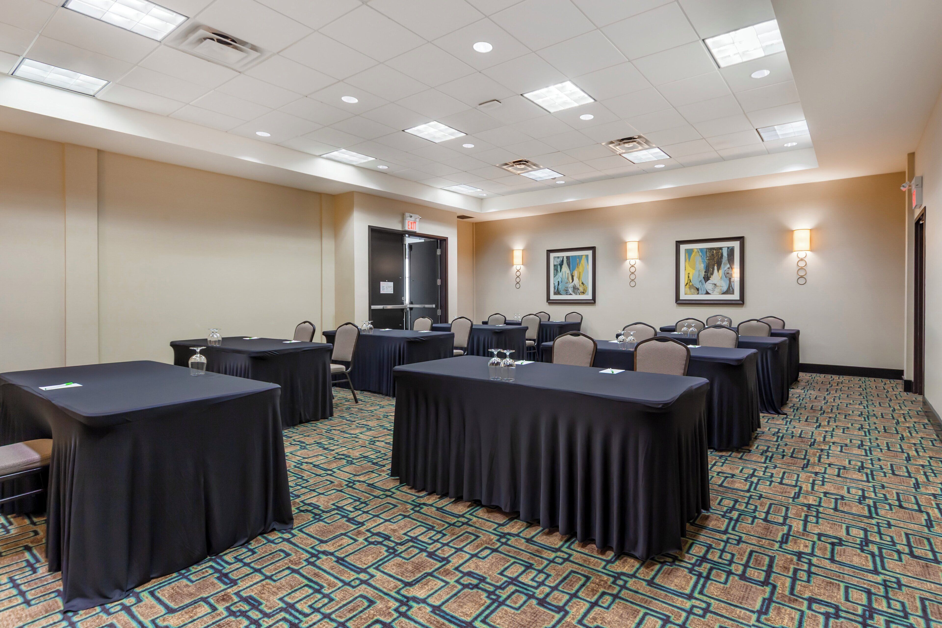 A conference room with tables, chairs, and artwork on the walls.