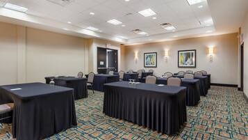 A conference room with tables, chairs, and artwork on the walls.