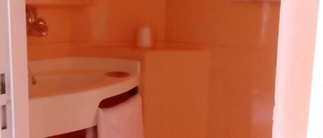 A bathroom with a white sink, a toilet, and a mirror.