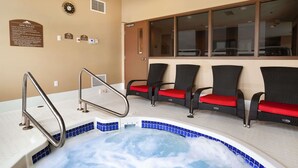 Zona de spa con hidromasaje, asientos y señalización informativa.