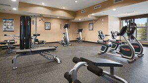 A gym with various exercise equipment, including treadmills, elliptical machines, and weight benches. - Microtel Inn & Suites by Wyndham Blackfalds Red Deer North (Blackfalds)