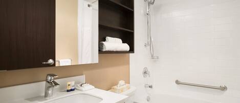Une salle de bain avec un lavabo, un miroir et une douche.