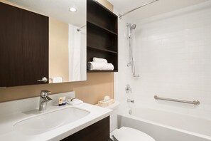 Un baño con lavabo, espejo y ducha.