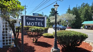 Señal de motel con un letrero de 'VACANCY', rodeada de jardines y una vista de la calle.