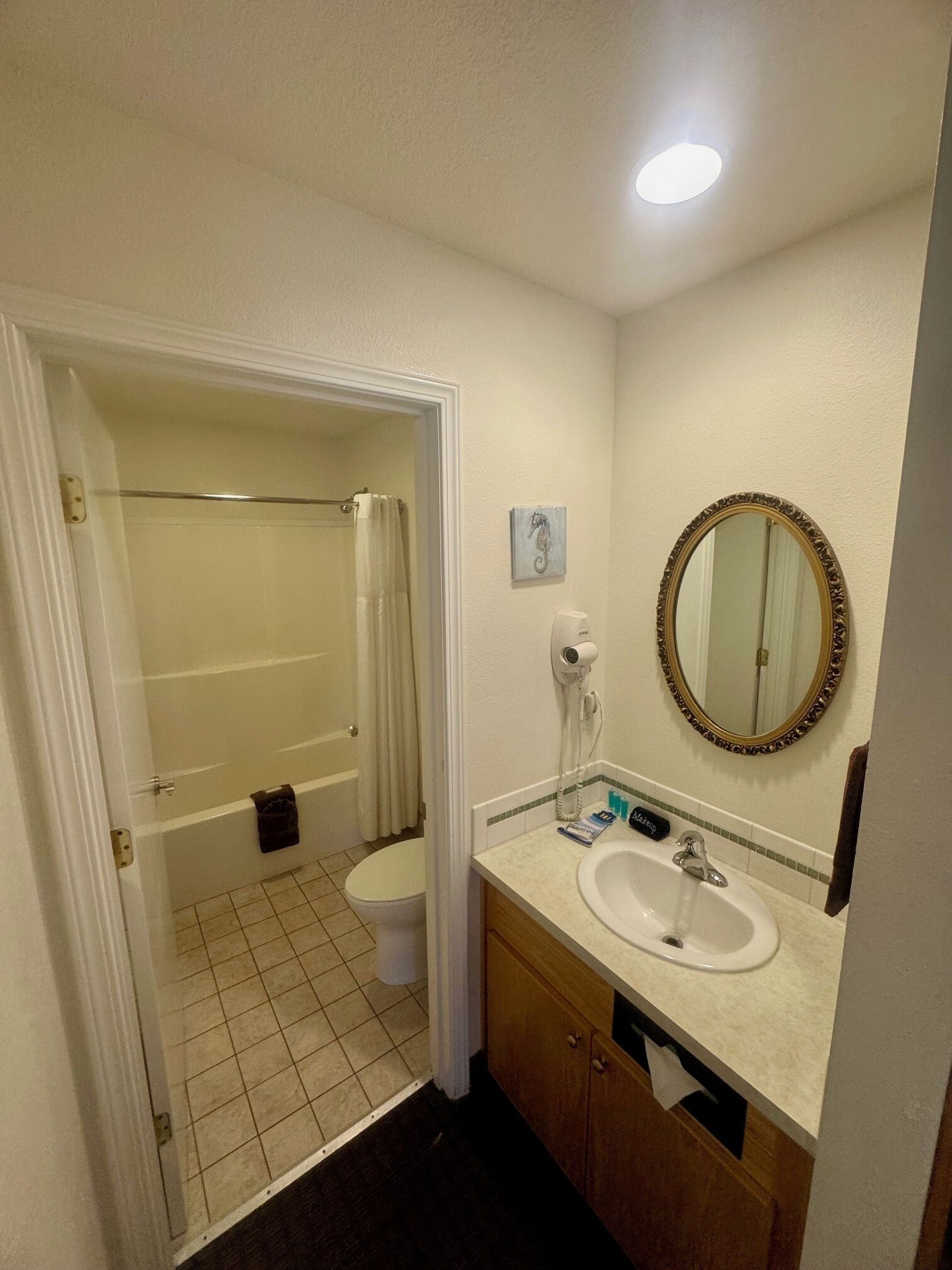 Une salle de bain comprenant des toilettes, un lavabo et un espace douche.