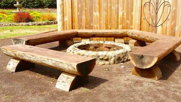 Un pozo de fuego circular con bancos de madera alrededor.