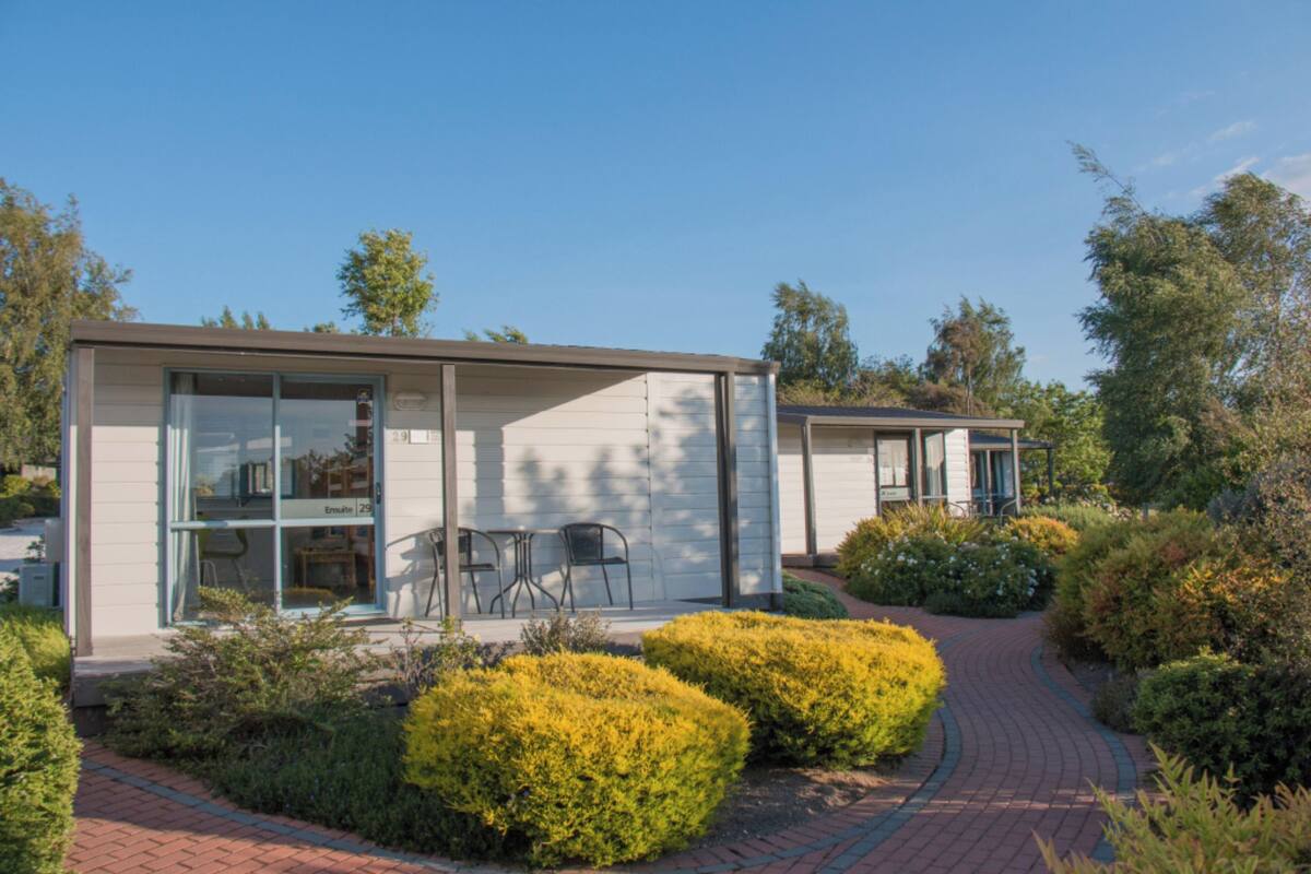Een modern gebouw met grote ramen en een geplaveid pad er naartoe.