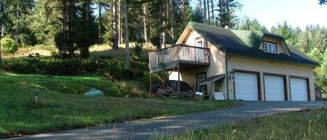 A two-story house with a balcony, a garage, and a driveway.
