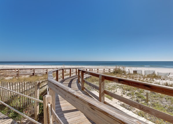 A wooden boardwalk leading to a beach with a clear view of the ocean. - Summer House on Romar Beach by Wyndham Vacation Rentals (Orange Beach)