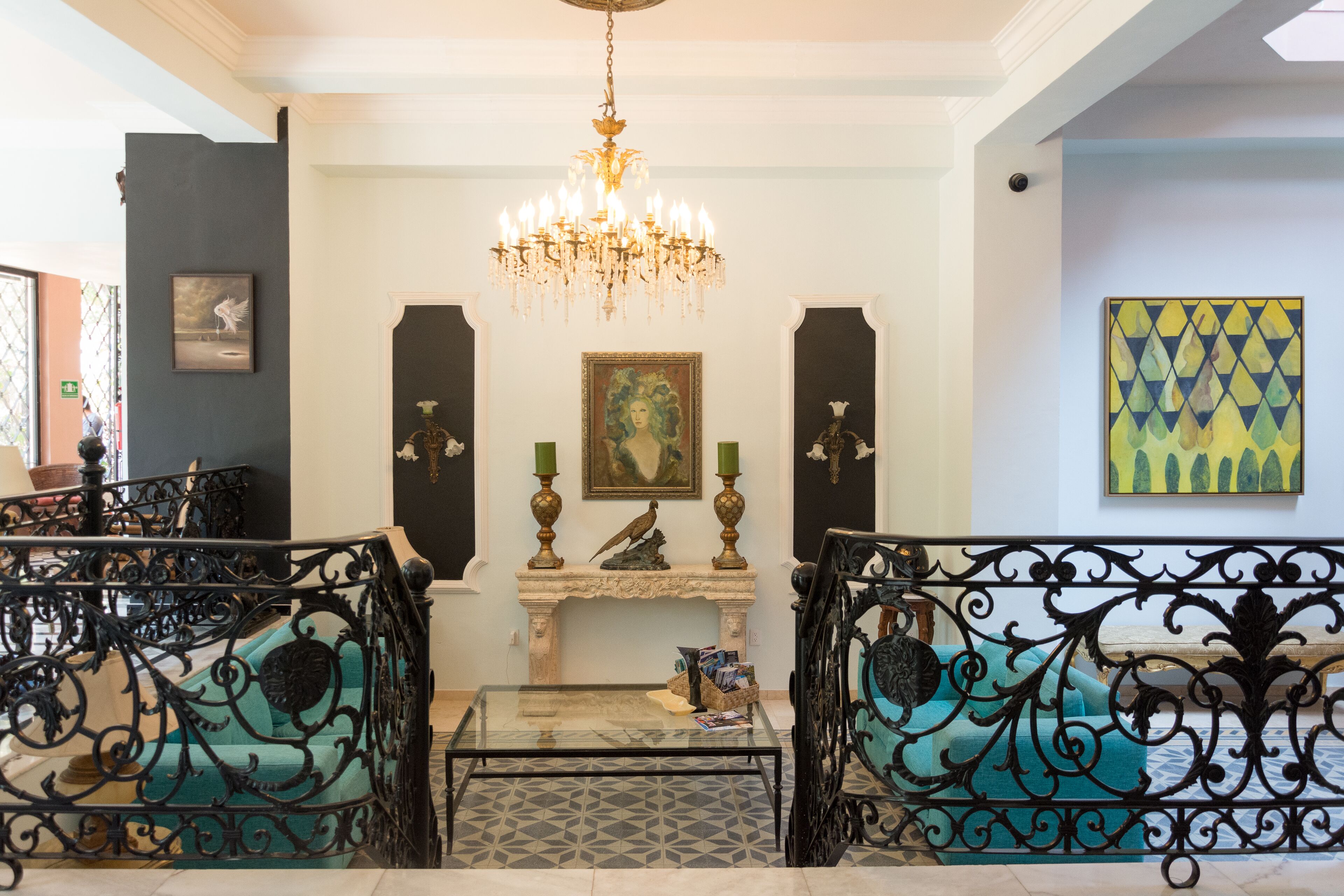 A lobby with a chandelier, a fireplace, and a painting on the wall.