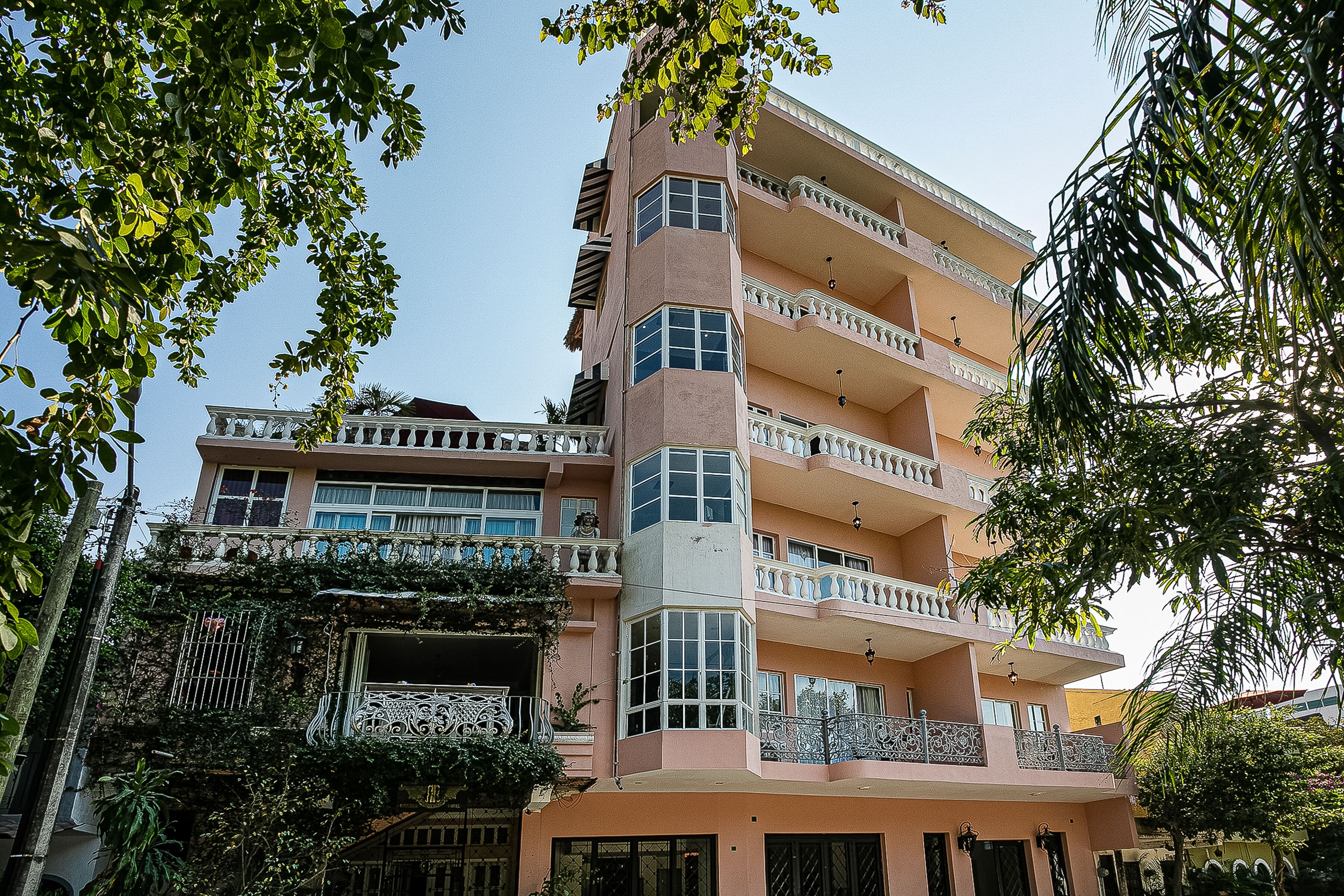 Un immeuble à plusieurs étages, doté de balcons, de grandes fenêtres et d’une entrée située à l’angle.
