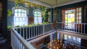 A multi-level interior with a balcony, a chandelier, and a view of the outdoors. - Rivera del Rio Boutique Hotel (Puerto Vallarta)