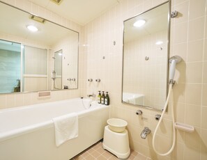 Un baño moderno con bañera, inodoro, bidé y un espejo grande.