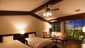 A hotel room with two beds, a ceiling fan, a table with a lamp, and a view of greenery through a window. - Coco Garden Resort Okinawa (Uruma)
