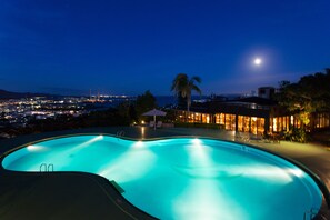 A swimming pool with a view of a cityscape at night. - Coco Garden Resort Okinawa (Uruma)