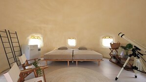 Un dormitorio con cama, mesitas de noche, lámpara, un trípode y una ventana.