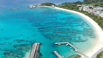 Pantai di sekitar, kursi berjemur, payung pantai, dan handuk pantai