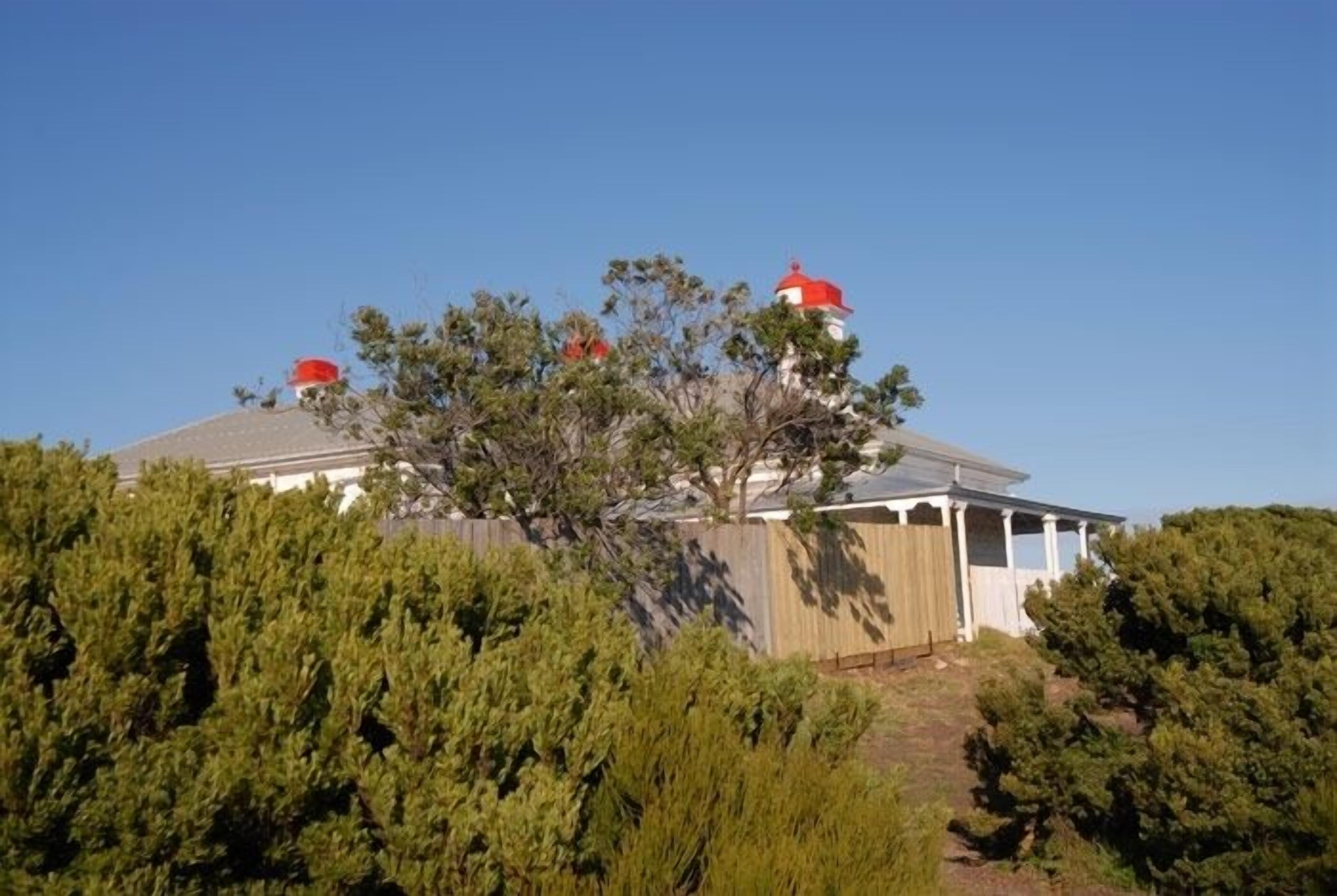 Un bâtiment surmonté d’un dôme rouge, entouré d’une végétation luxuriante.