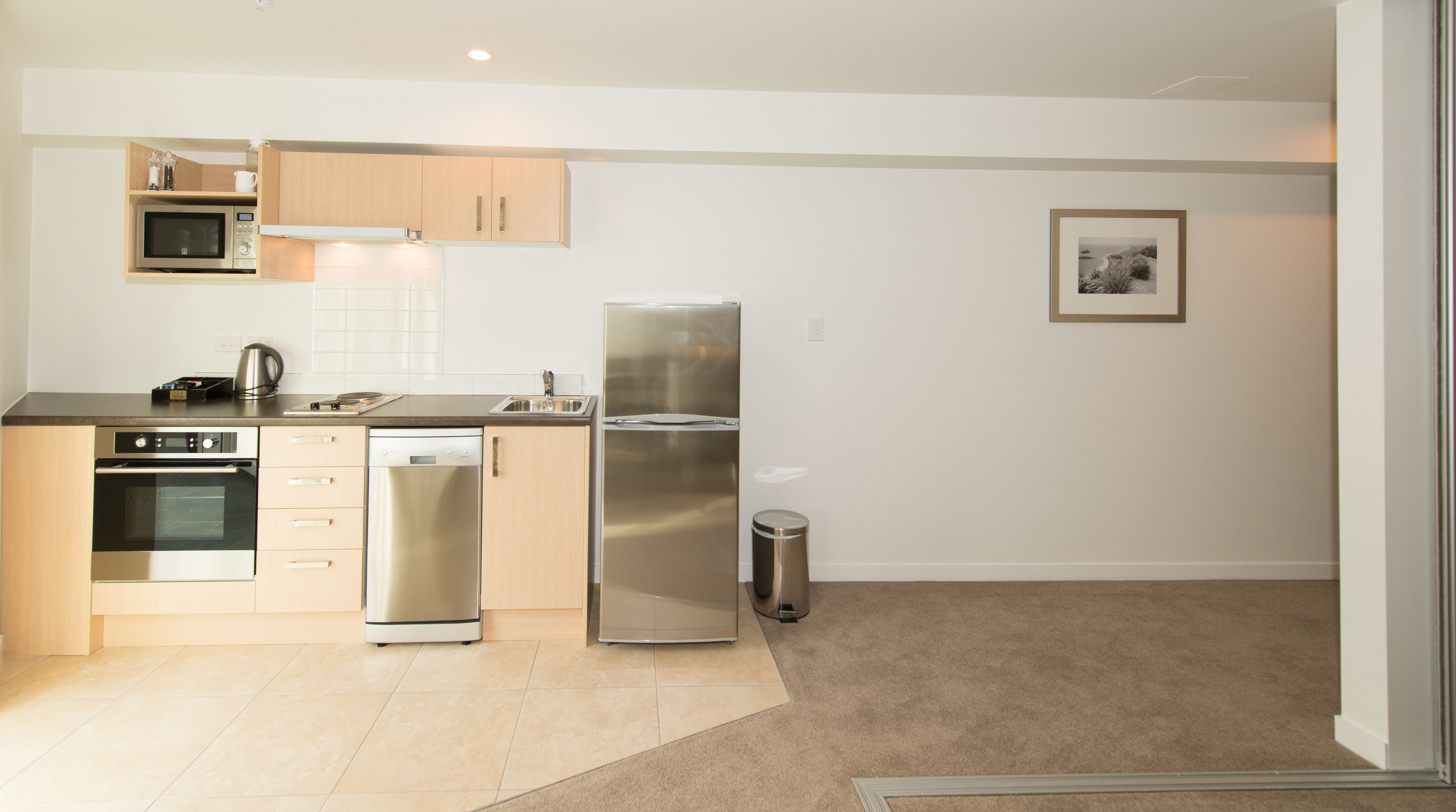 A modern kitchen with stainless steel appliances, a dishwasher, and a microwave.
