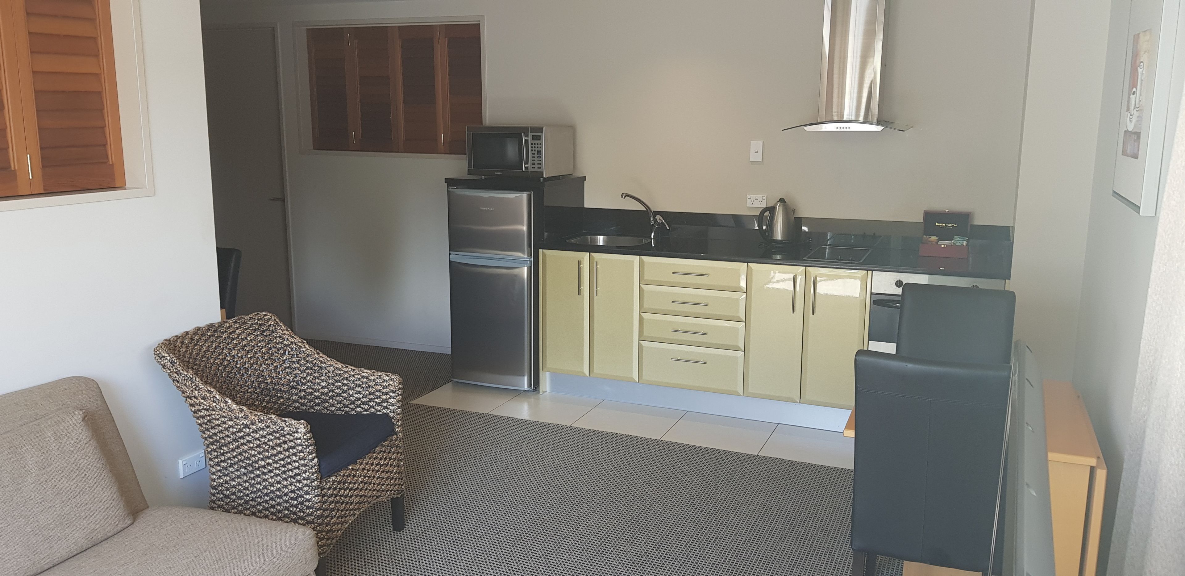 A compact kitchen with a refrigerator, microwave, and sink.