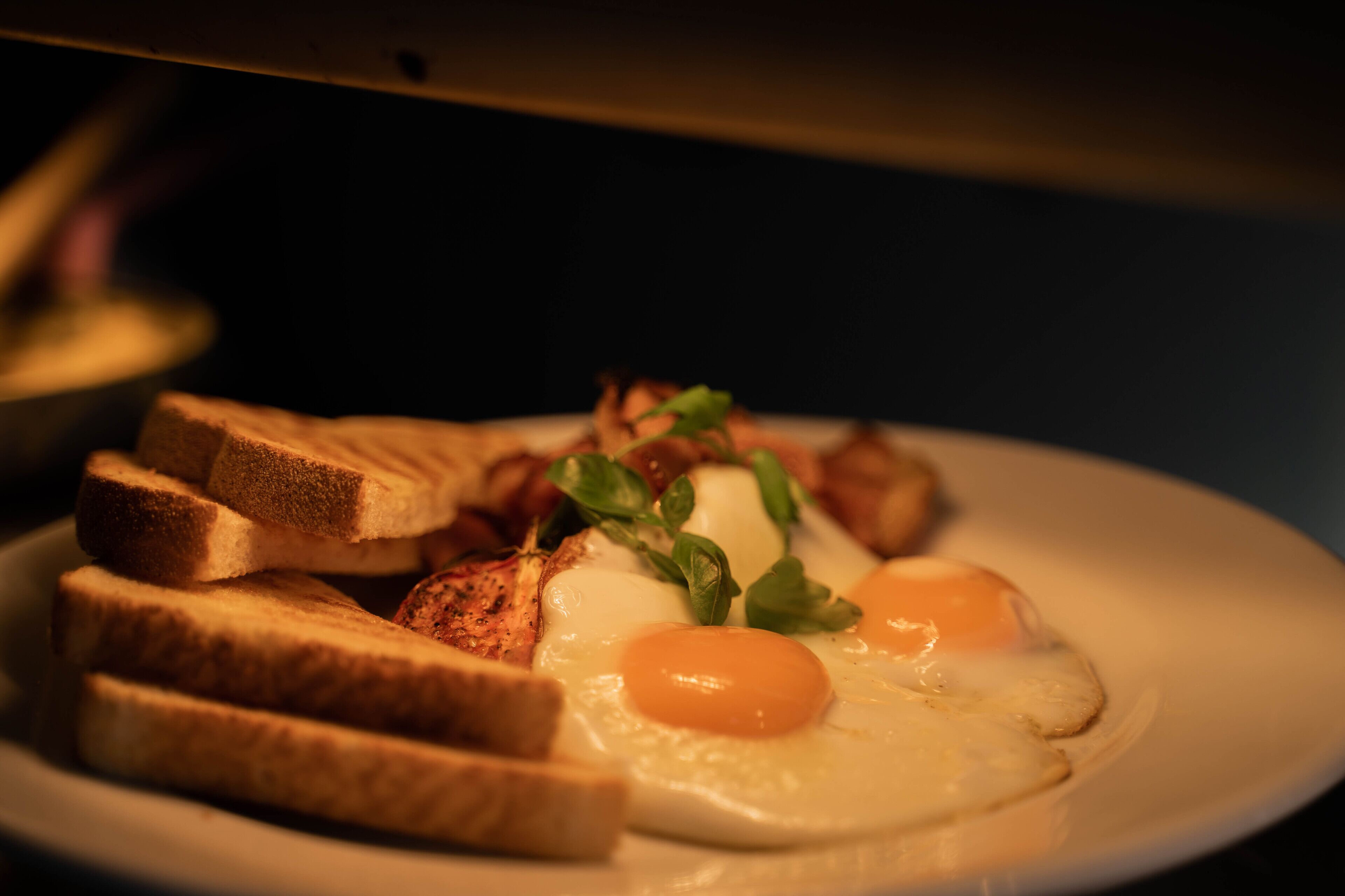 A plate of food with toast, eggs, and greens.