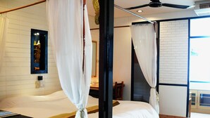 Een kamer met een bed, een houten hoofdbord, een spiegel en een raam met gordijnen.
