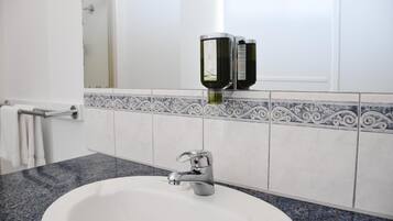 A bathroom with a white sink, a modern faucet, and a decorative tile backsplash.