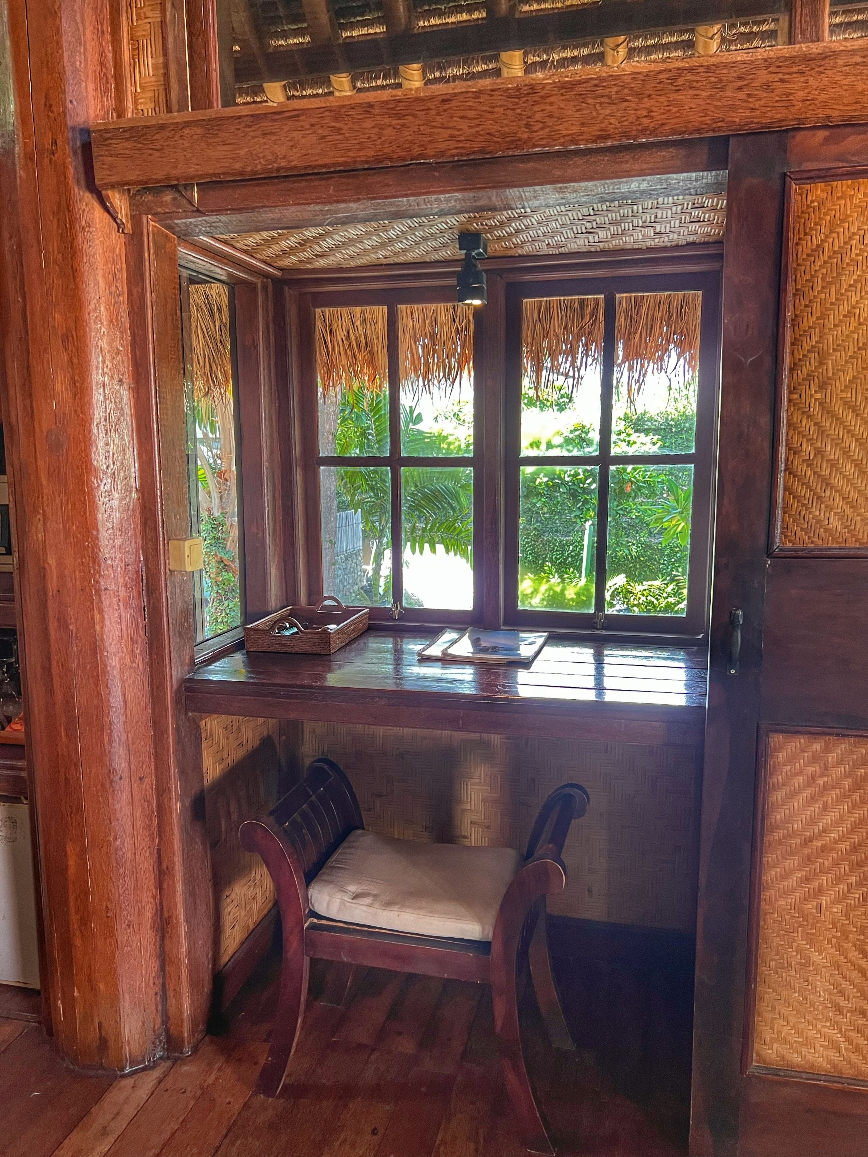 A wooden room with a bench, a window, and a door.