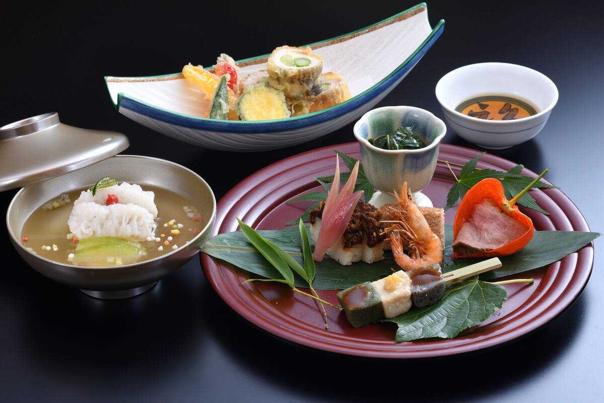 A variety of Japanese dishes including sushi, sashimi, and a bowl of soup.
