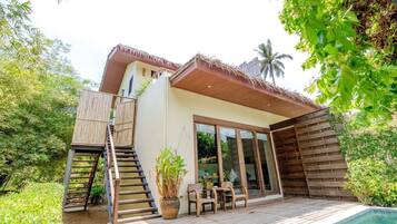 A modern house with a wooden deck, a staircase, and a pool.