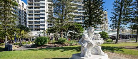 Una estatua en un parque, con edificios modernos al fondo.