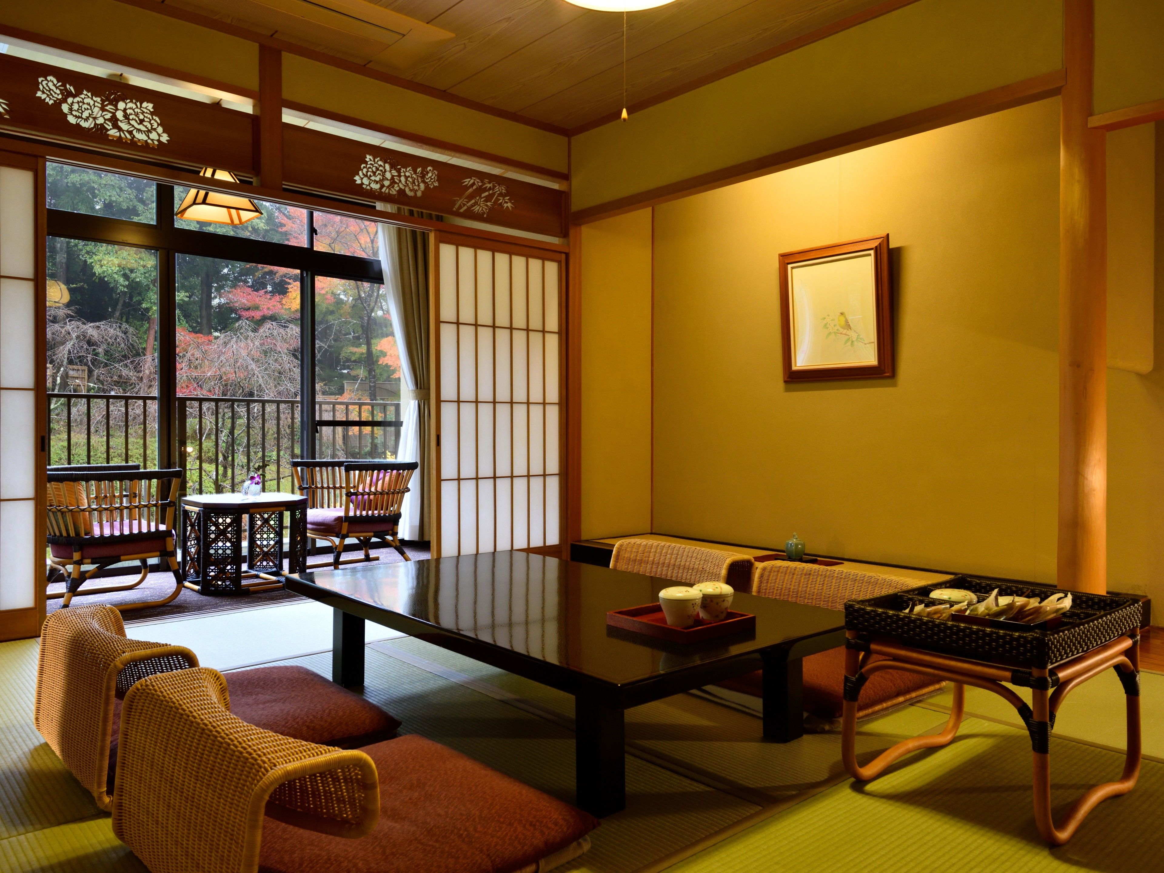 A traditional Japanese room with tatami flooring, a low table, and a sofa.