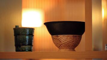A wooden shelf with a ceramic bowl and a small container.