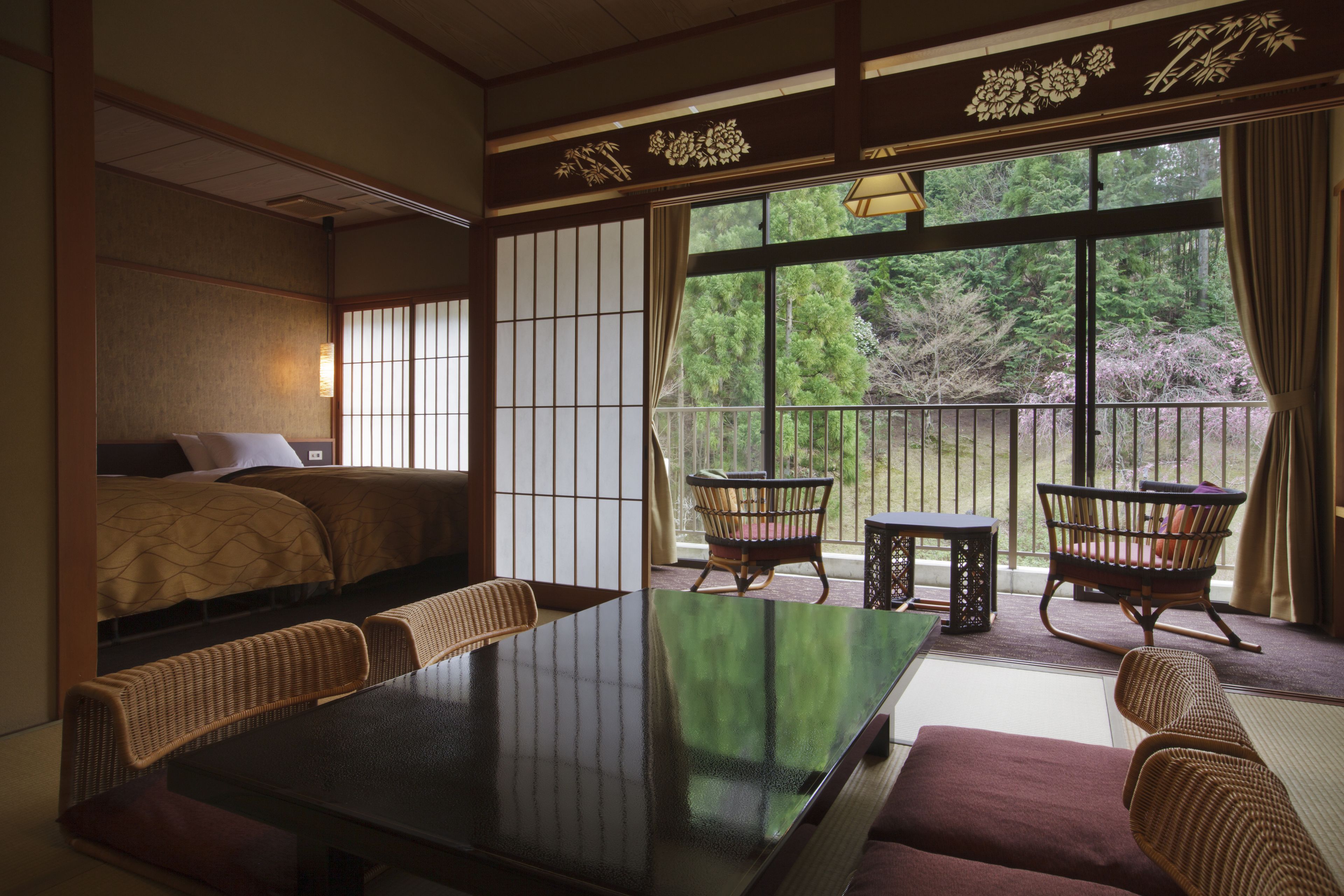 A traditional Japanese-style room with tatami flooring, a low table, and a futon bed.