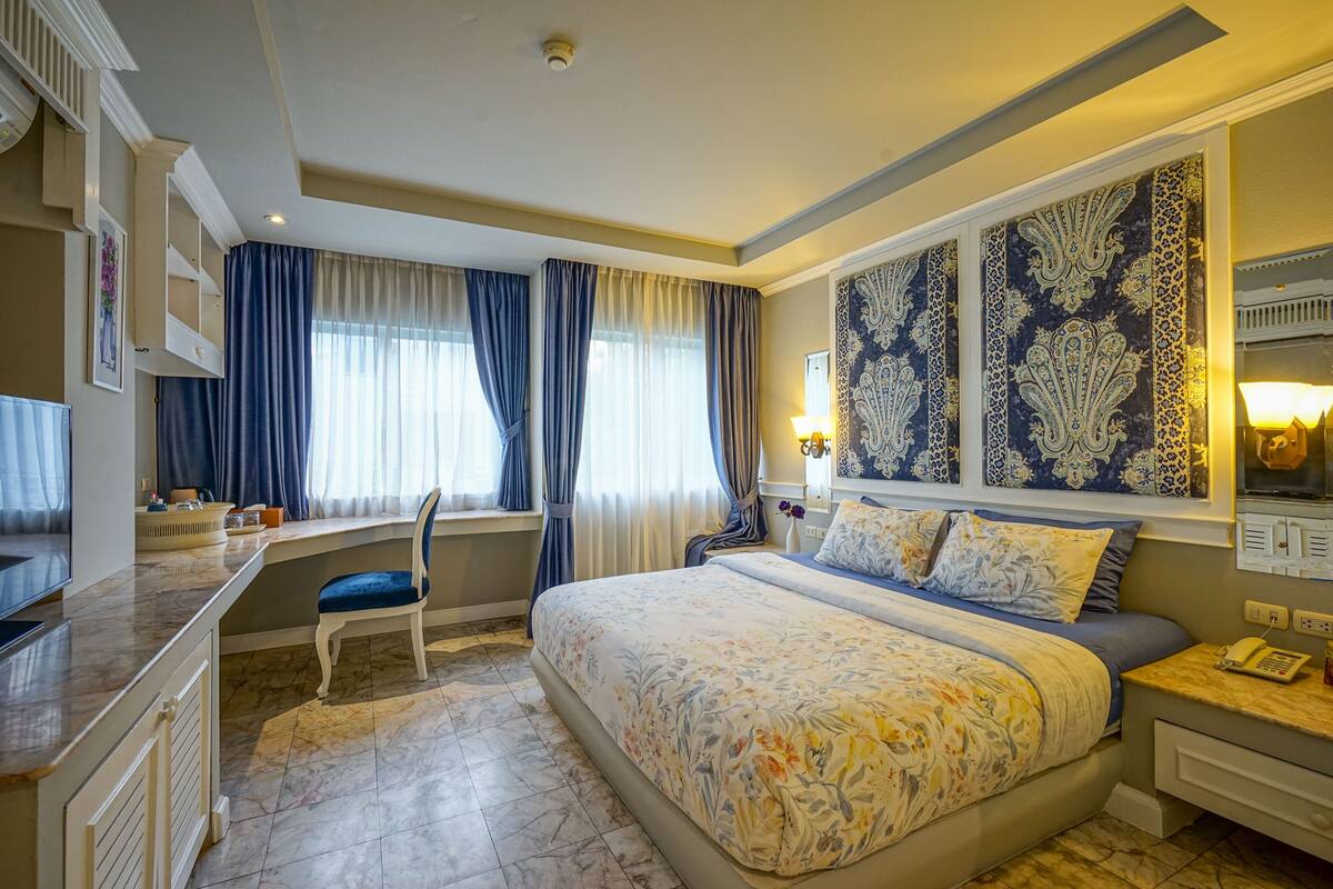 Habitació d'hotel amb un llit gran, una taula i una cadira.