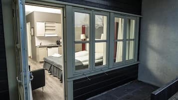 Una stanza con un letto, un angolo cottura e una finestra a più vetri.