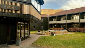 A reception area with a sign, outdoor seating, and a view of hills. - Oppdal Gjestetun Hotell (Oppdal)