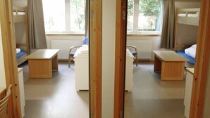 A room with bunk beds, a desk, a chair, and a window. - Roligheden Ferieleiligheter (Kristiansand)