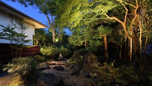 A serene garden with a pathway, rocks, and trees. - Ogoto Onsen Yunoyado Komolebi (Otsu)