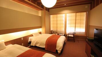 Une chambre d’hôtel avec deux lits, une télévision, un bureau et une fenêtre donnant sur un paysage agréable.
