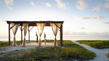 A beachside gazebo with a view of the ocean.