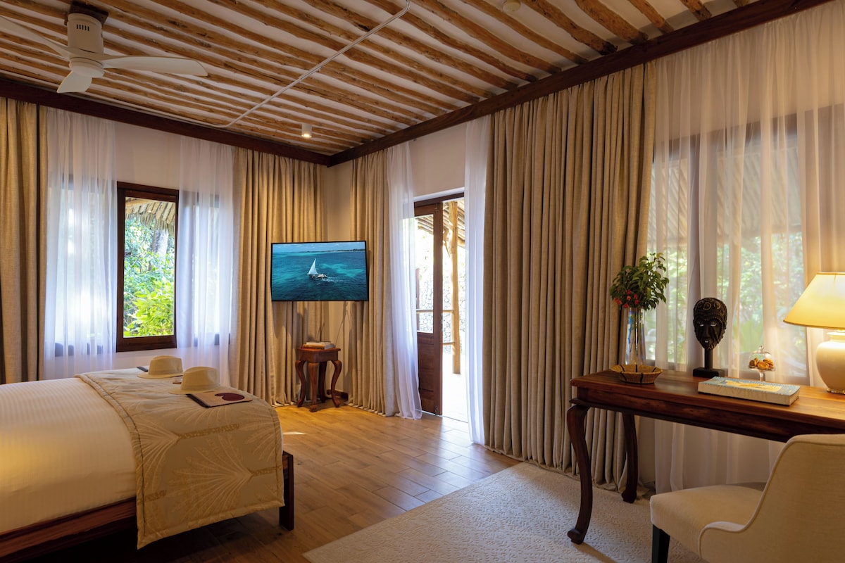 A hotel room with a bed, a television, a desk, and a chair.