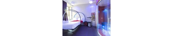 A modern hotel room with a bed, a circular window, and a shower area. - Guesthouse o Affittacamere Magenta Pantheon Navona (Rome)