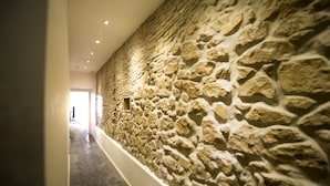 Un pasillo con pared de piedra y suelo de baldosas.